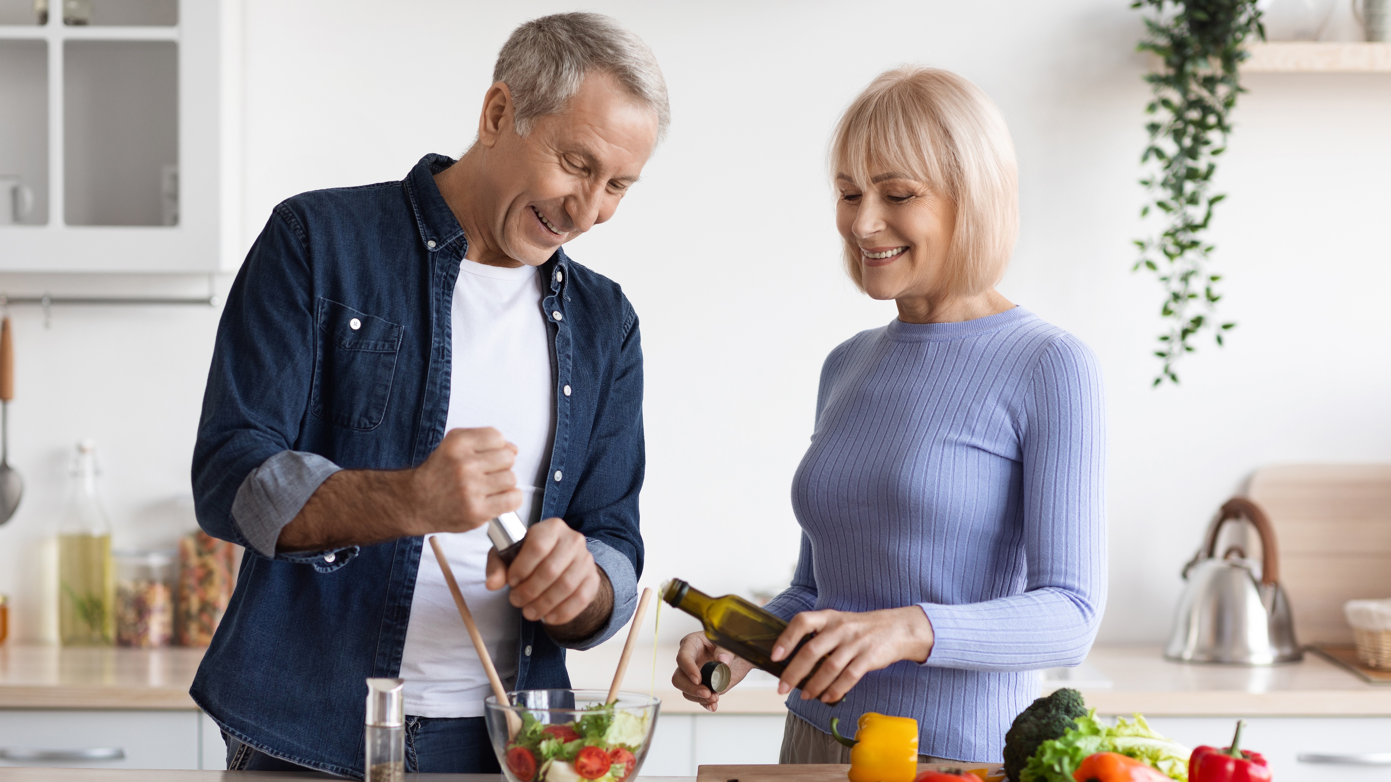 Attractive mature man and woman cooking together at home
