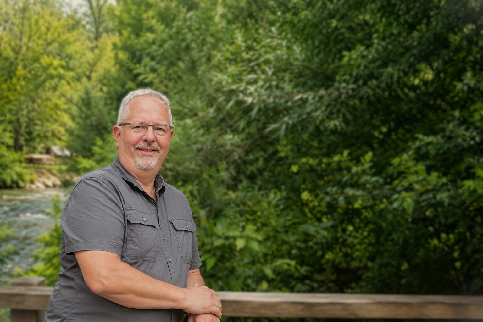 Kurt Shinn standing beside a river surrounded by trees